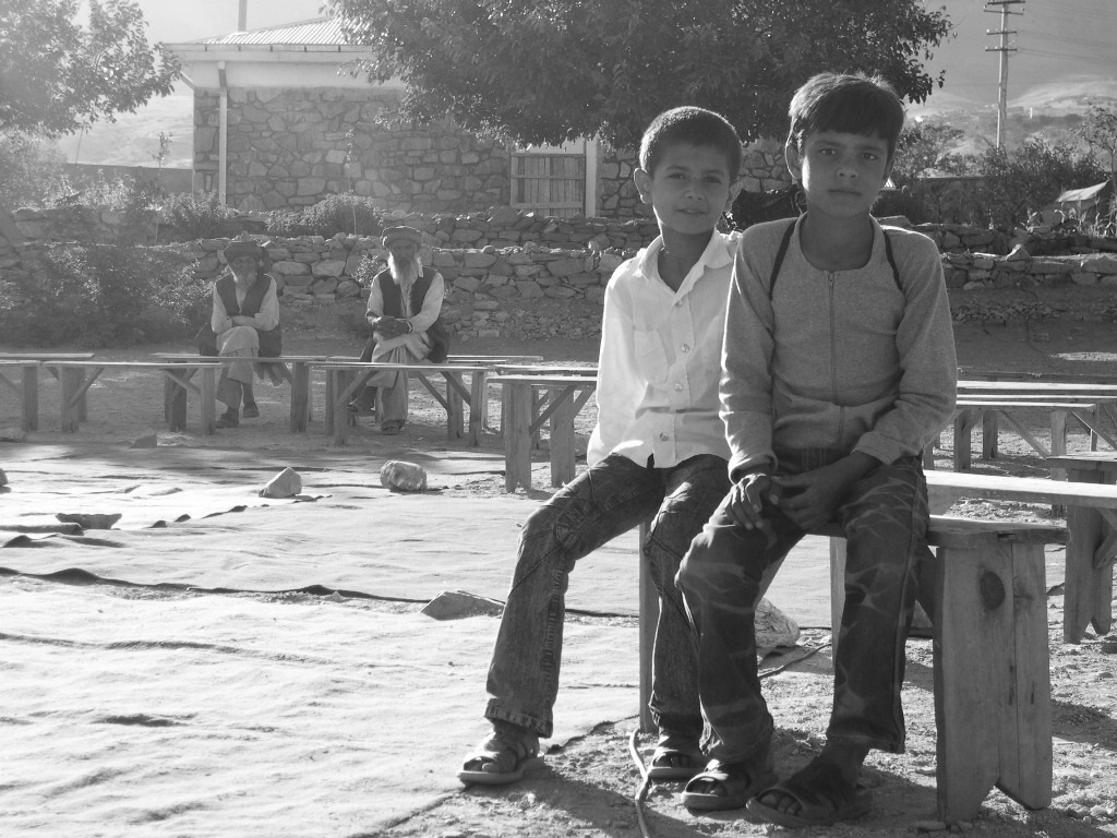 Photo d'archive de 2005, la compagnie Hasards d'Hasards. Deux enfants assis sur un banc à Tccharekar, en Afghanistan.