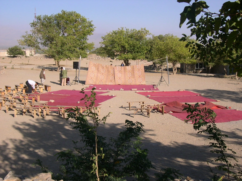 Photo d'archive de 2005, la compagnie Hasards d'Hasards. Des personnes préparent le dispositif scénique du spectacle : Histoire des rois, dans la cours de l'école élémentaire de Tccharekar, en Afghanistan. Avec l'association Afrane.