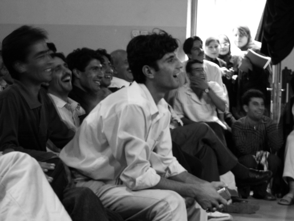 Photo d'archive d'Afghanistan. Compagnie Hasards d'Hasards. Photo en noir et blanc du public. Des visages souriants.