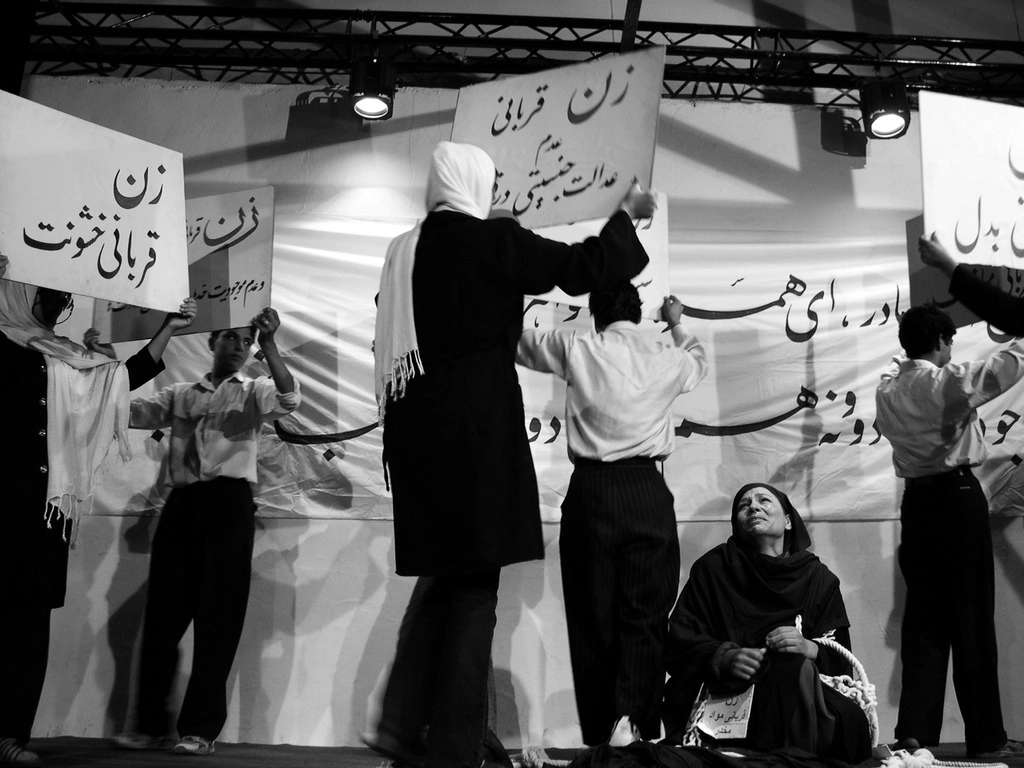 Photo d'archive d'Afghanistan. Compagnie Hasards d'Hasards. Photo de représentation du spectacle "Je ne suis pas inférieure en genre" Kaboul. Le mot « زن » (zan) apparaît plusieurs fois : il signifie « femme ». On lit aussi « ترابي » (turabi), qui signifie « de terre » ou « terrestre ».