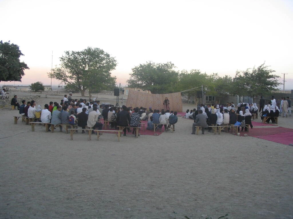 Photo d'archive de 2005, la compagnie Hasards d'Hasards. Le public attend pour voir le spectacle : Histoire des rois, dans la cours de l'école élémentaire de Tccharekar, en Afghanistan. Avec l'association Afrane.
